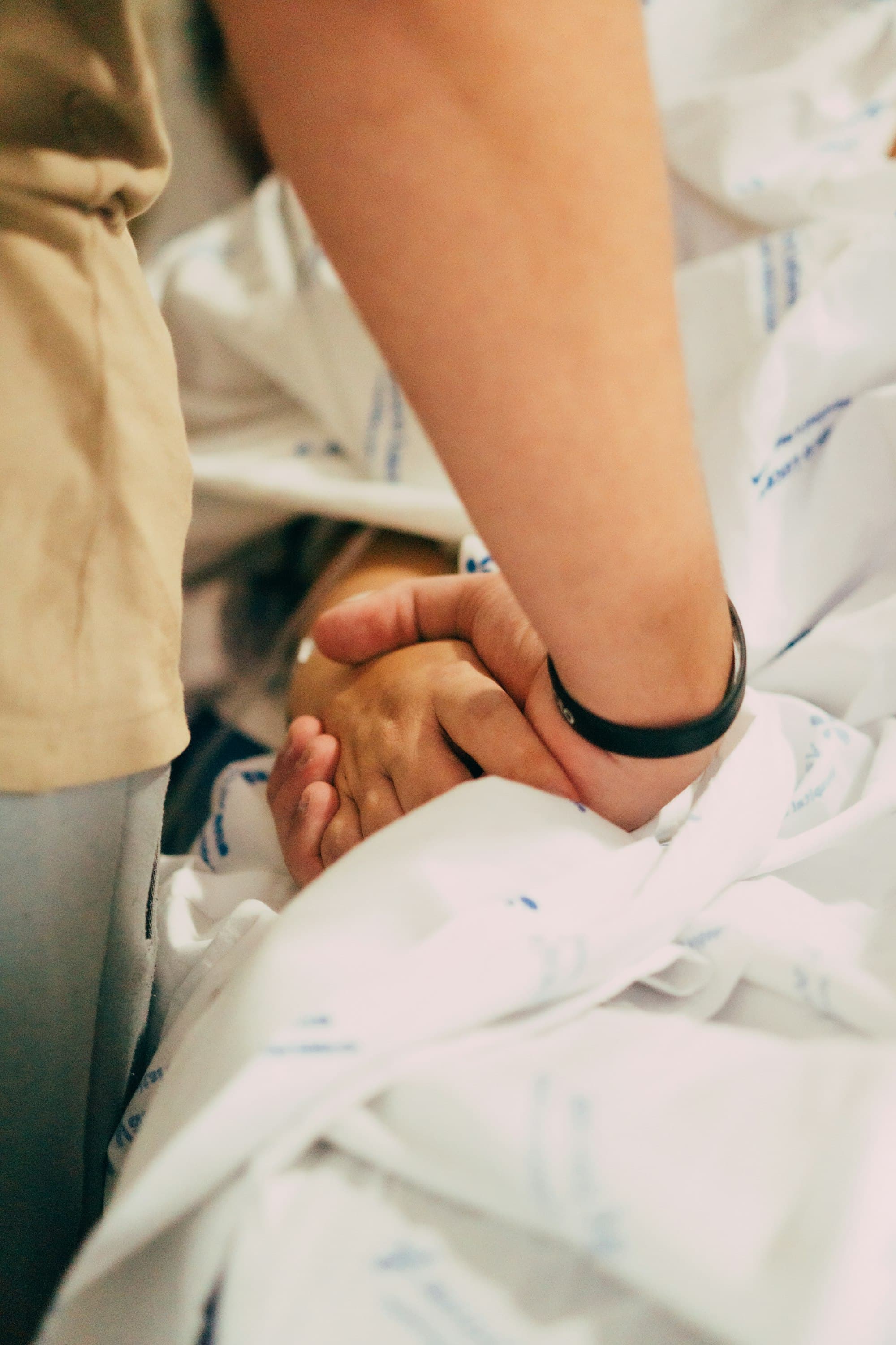 A caregiver holding a patient's hand
